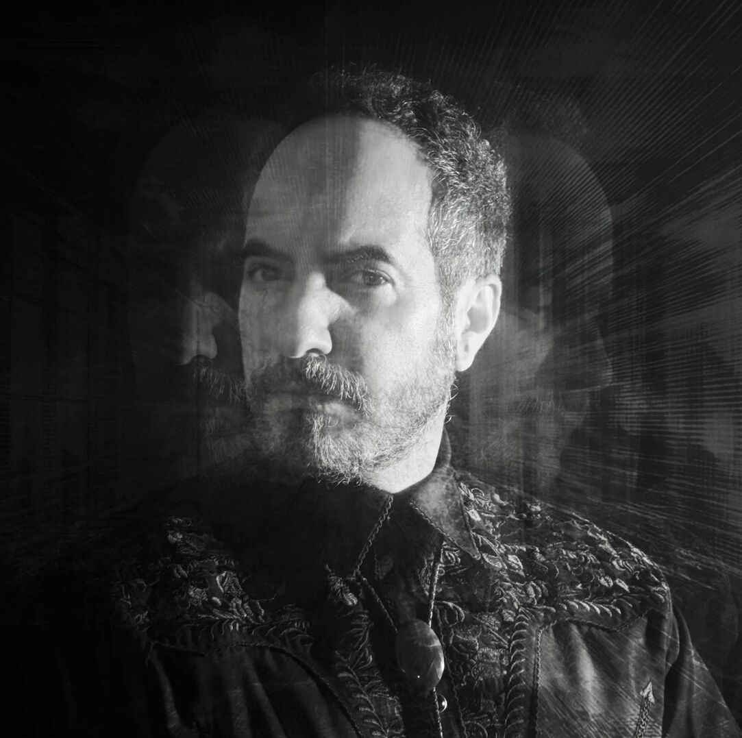 Double-exposure portrait of SOHEILL, two versions of his face overlapped.