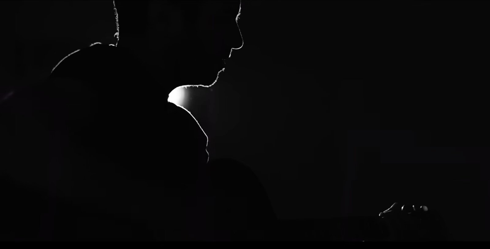 The Doorway — a lit profile emerging from darkness, still from the music video.